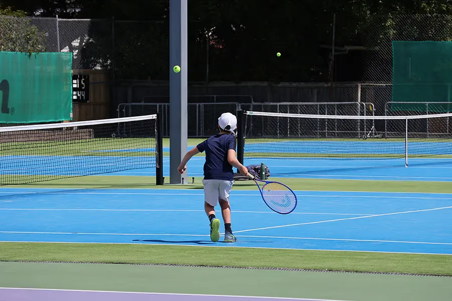 A young boy practicing on the courts at the Waimairi Tennis Club